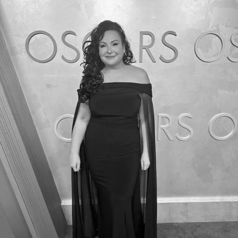 Catherine Lyn Scott wearing a black dress next to a sign saying 'Oscars'.